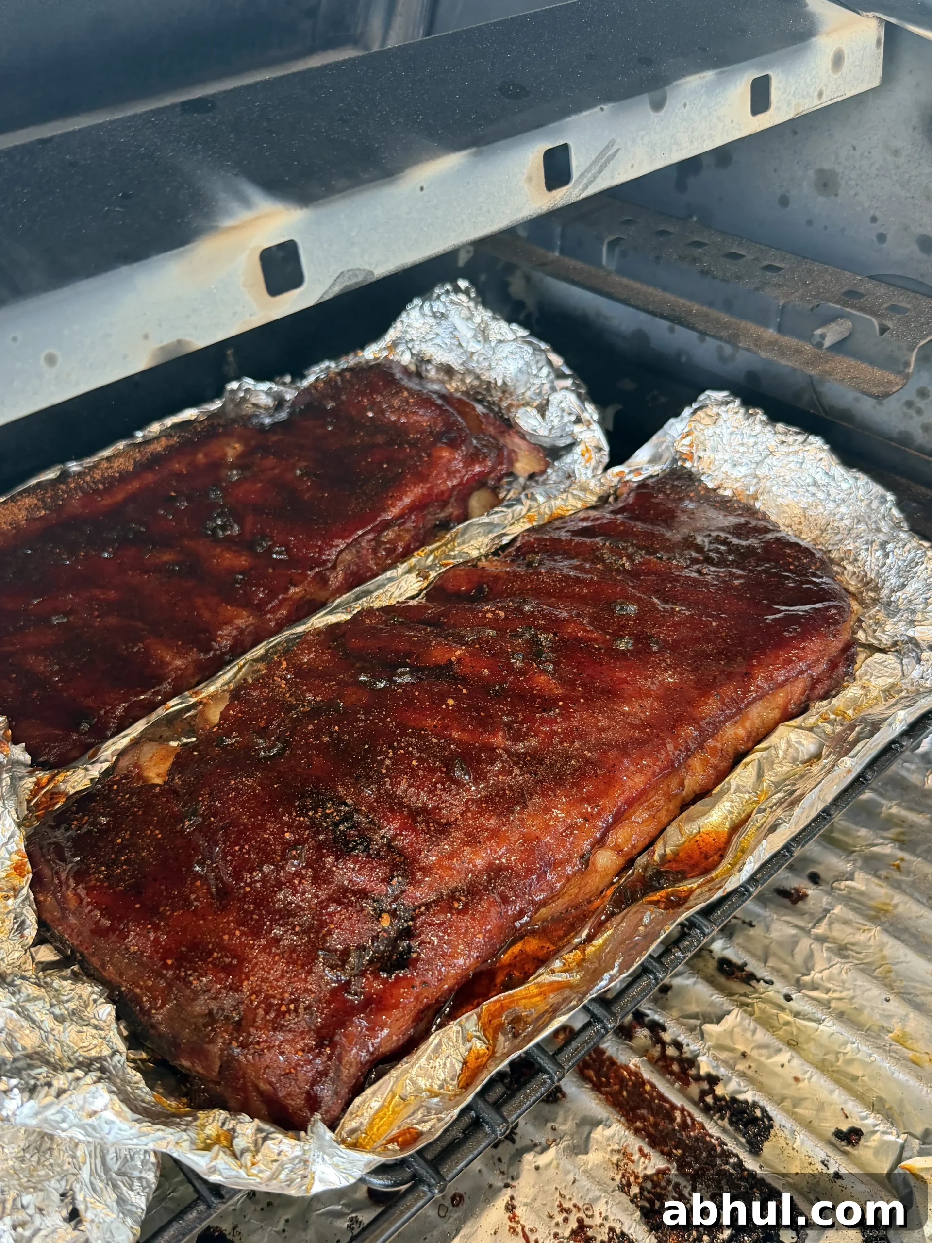 Smoked ribs wrapped in foil on a pellet grill
