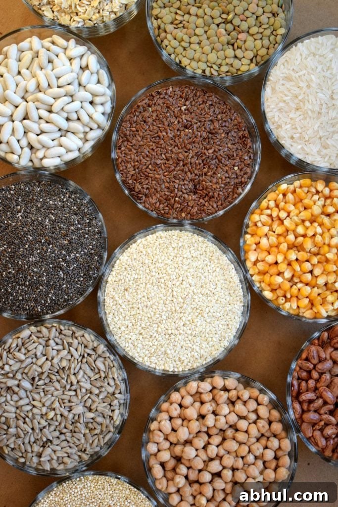 Bowls of dried whole grains displayed on wooden table.
