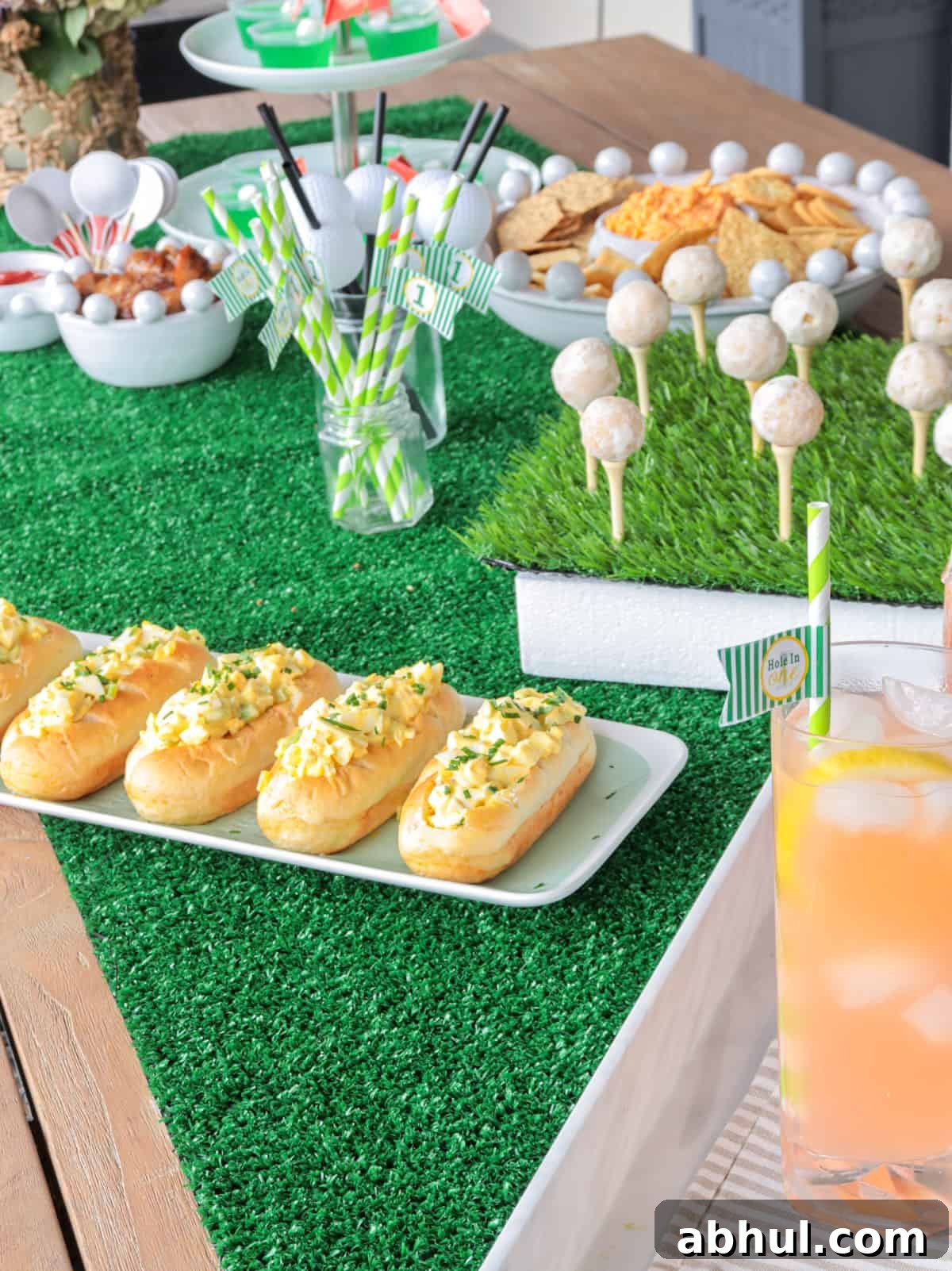 Table with turf and food for golf tournament.