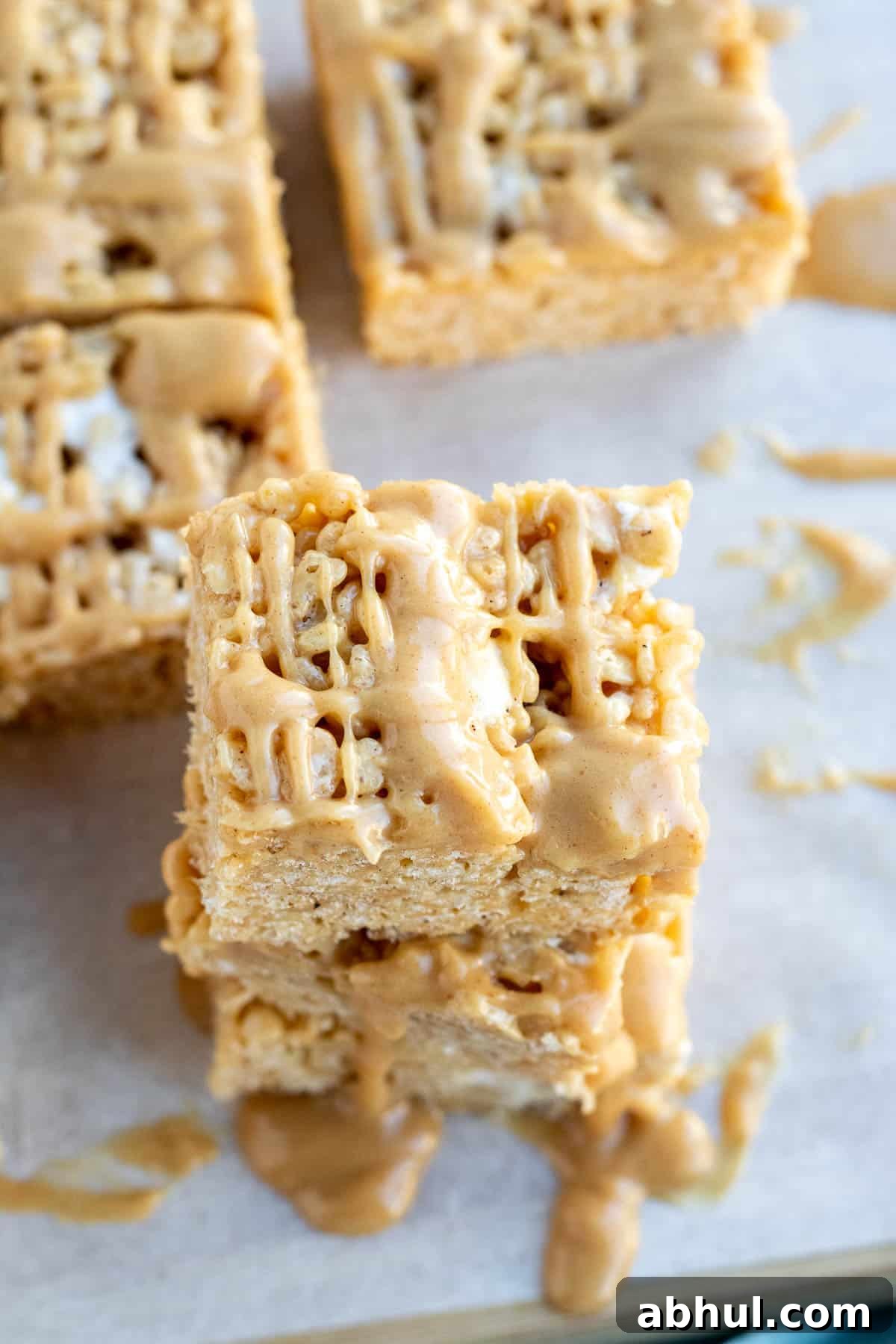 close up of a peanut butter rice krispie bar with a peanut butter drizzle