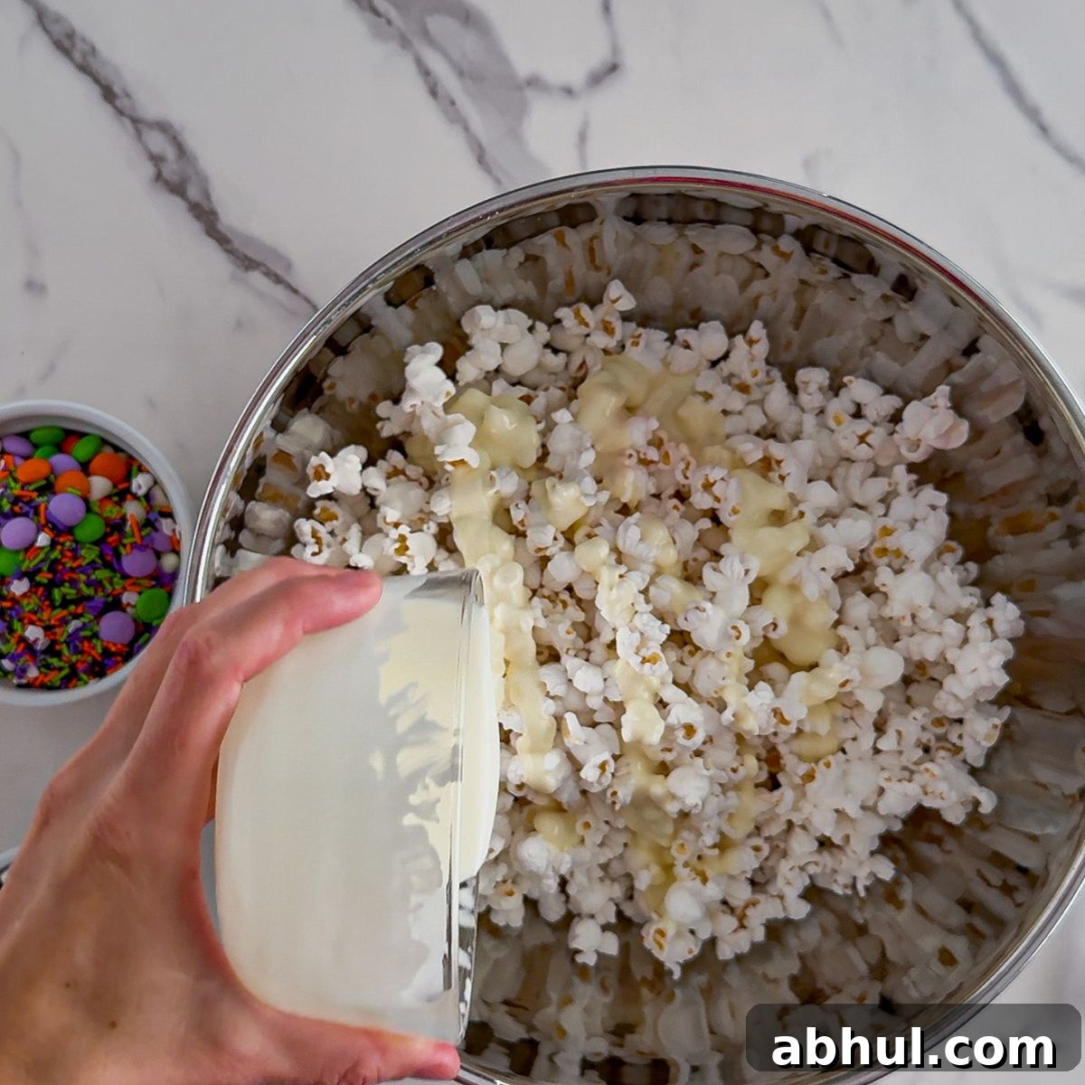 Pouring on the melted white chocolate.