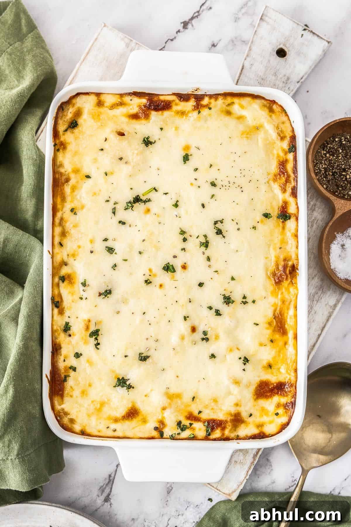 White rectangular dish of Mediterranean Sausage Pasta Bake, topped with a sprinkling of fresh parsley.
