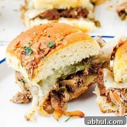 Philly cheesesteak sliders on a plate.