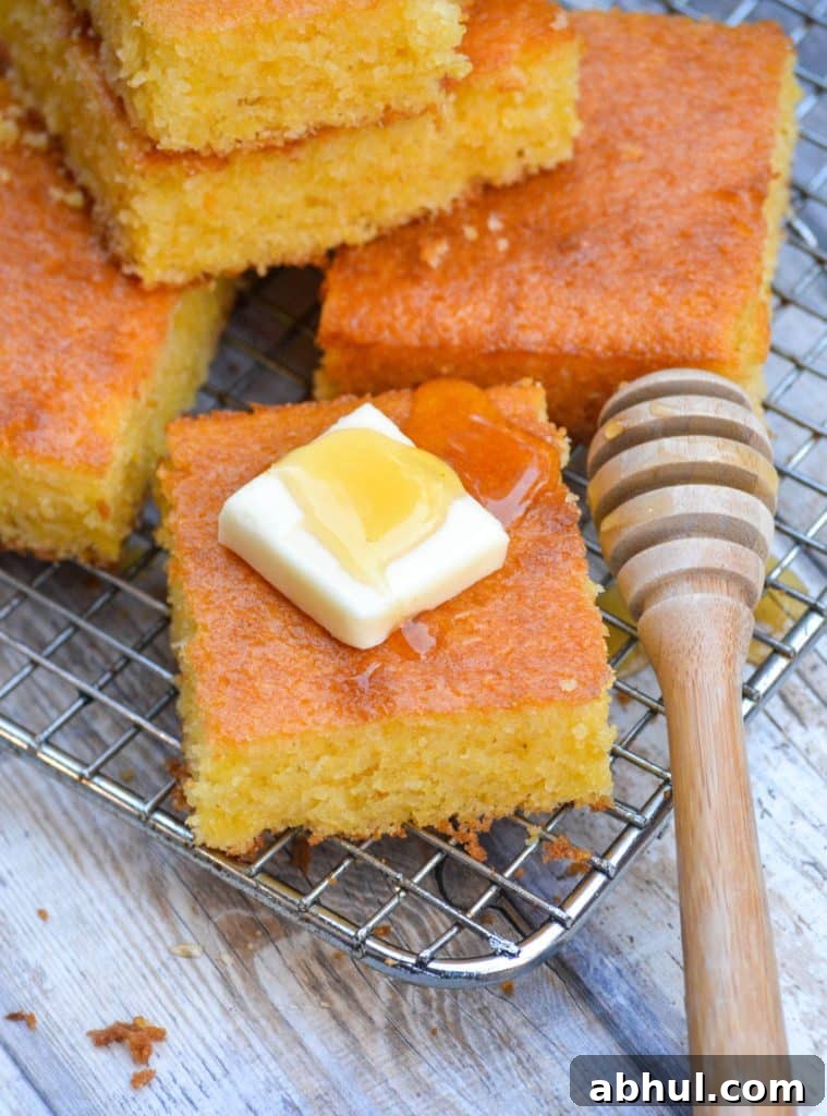 Make Moister Cornbread from a Box 7 a square piece of Southern style cornbread topped with a pat of butter and drizzle of honey