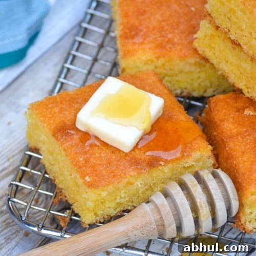 Make Moister Cornbread from a Box 8 a square piece of Southern style cornbread topped with a pat of butter and drizzle of honey