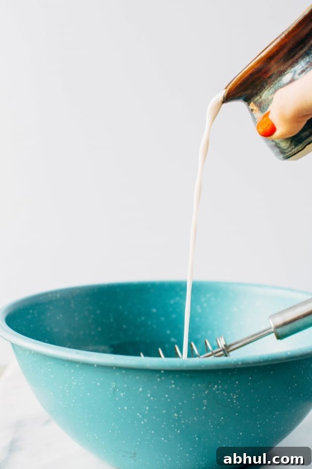Pouring almond milk for everything (but the) bagel sheet pan eggs with smoked salmon. A super easy and healthy way to set yourself up for weekday breakfast success! Also the best possible way to indulge in your love of everything bagels WITHOUT eating a bagel.