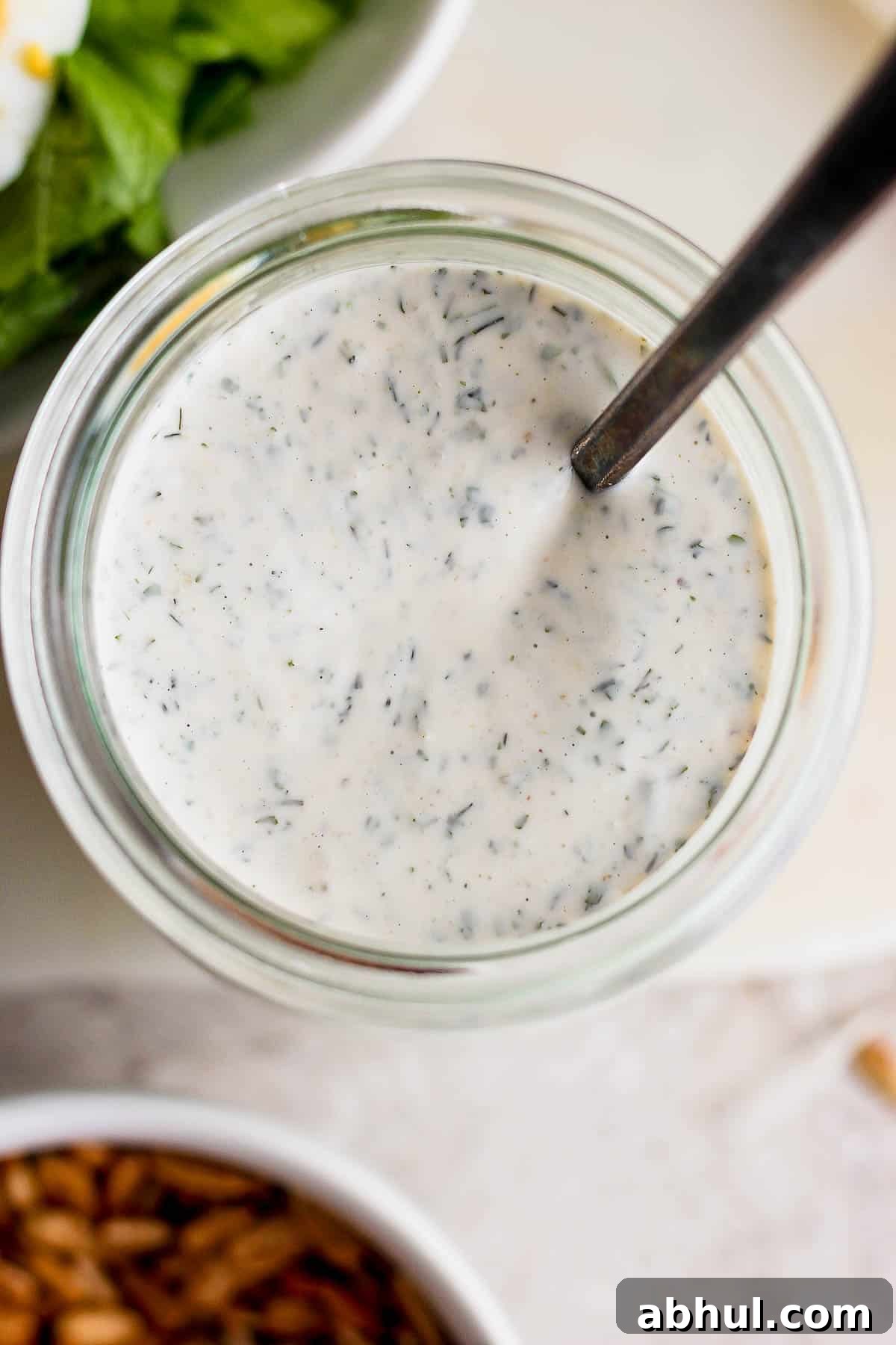 Homemade Herb Ranch Dressing Recipe for Fresh Flavor 2 Ranch dressing in a mason jar with a spoon.