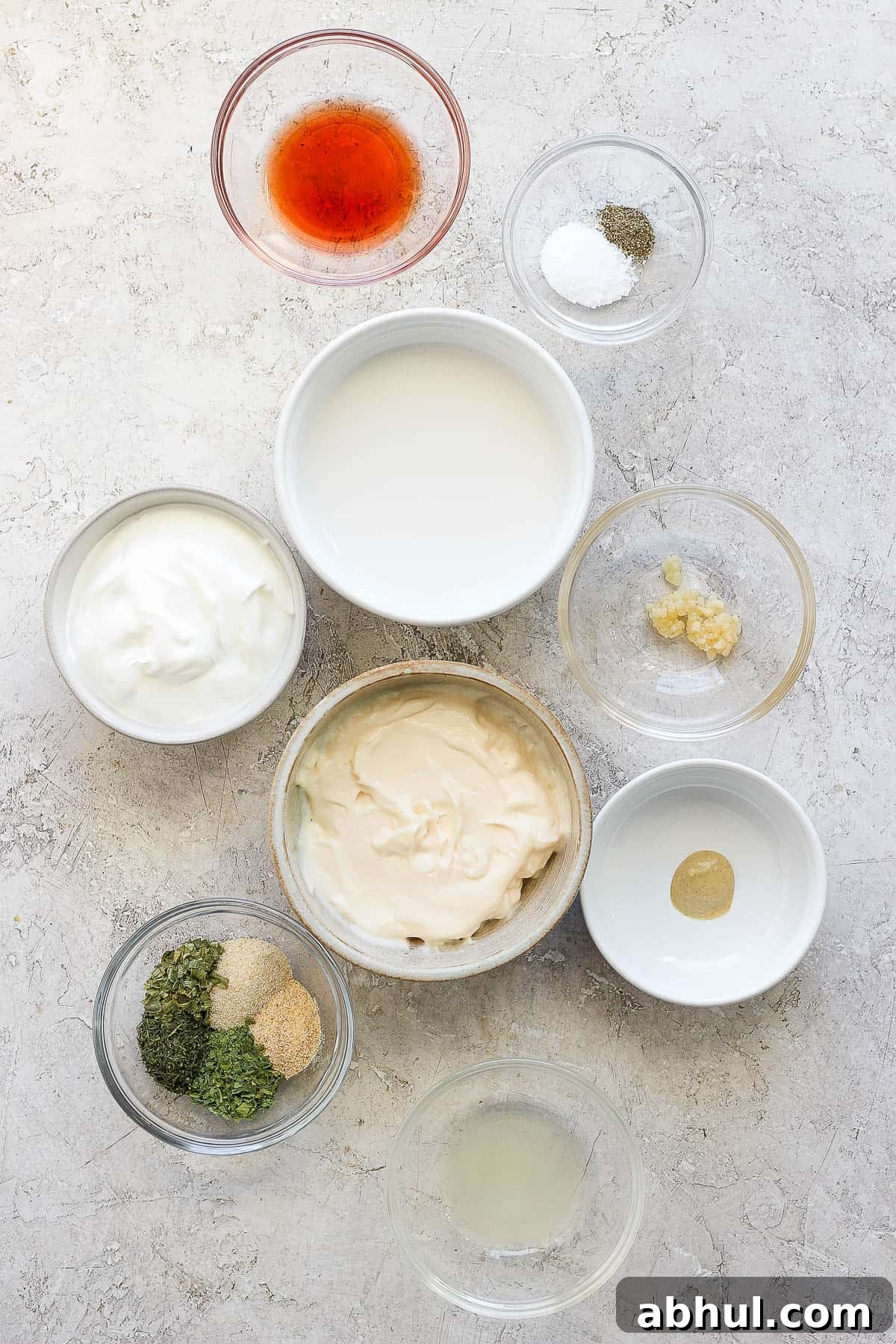 Homemade Herb Ranch Dressing Recipe for Fresh Flavor 3 Individual bowls of mayo, sour cream, dijon mustard, minced garlic, dried herbs, lemon juice, salt & pepper, red wine vinegar, and milk.