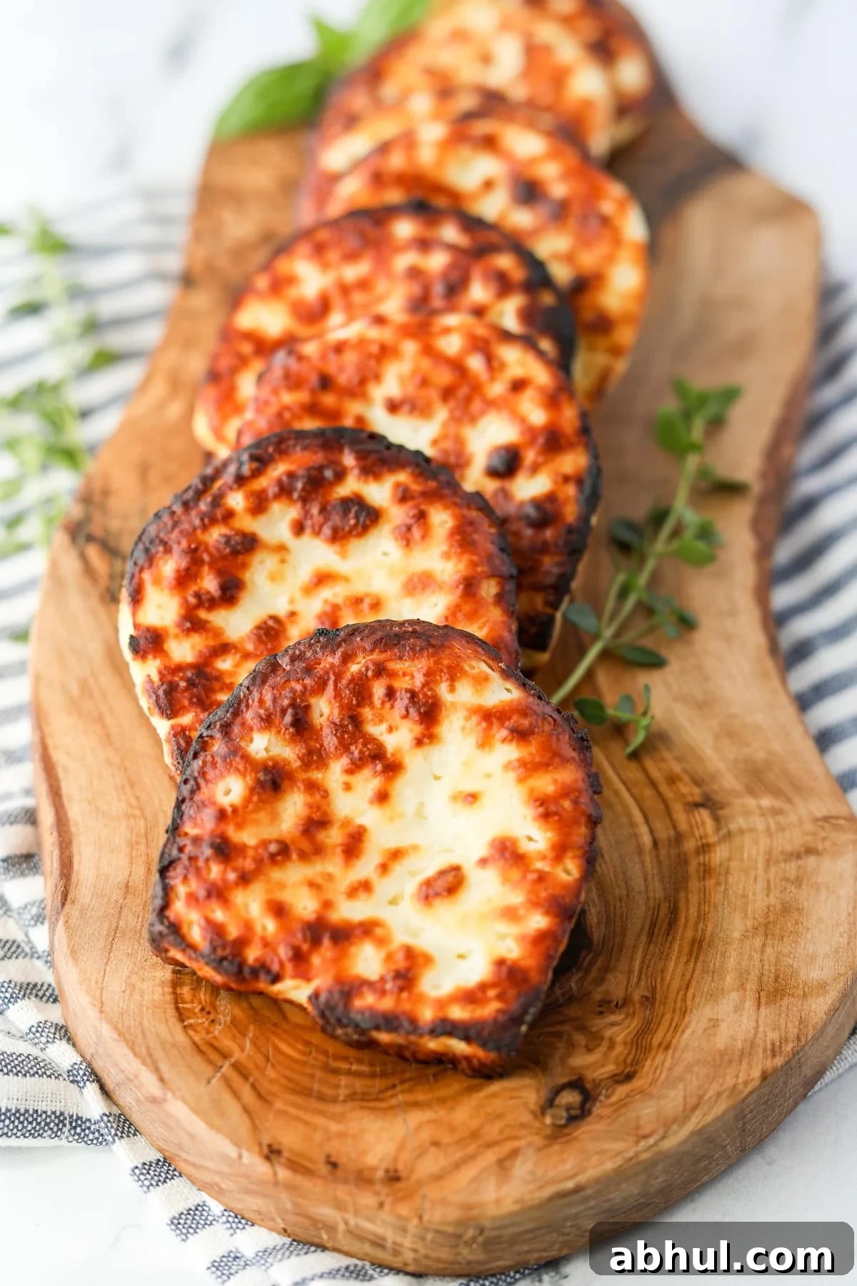 Slices of fried cheese on a wooden board.