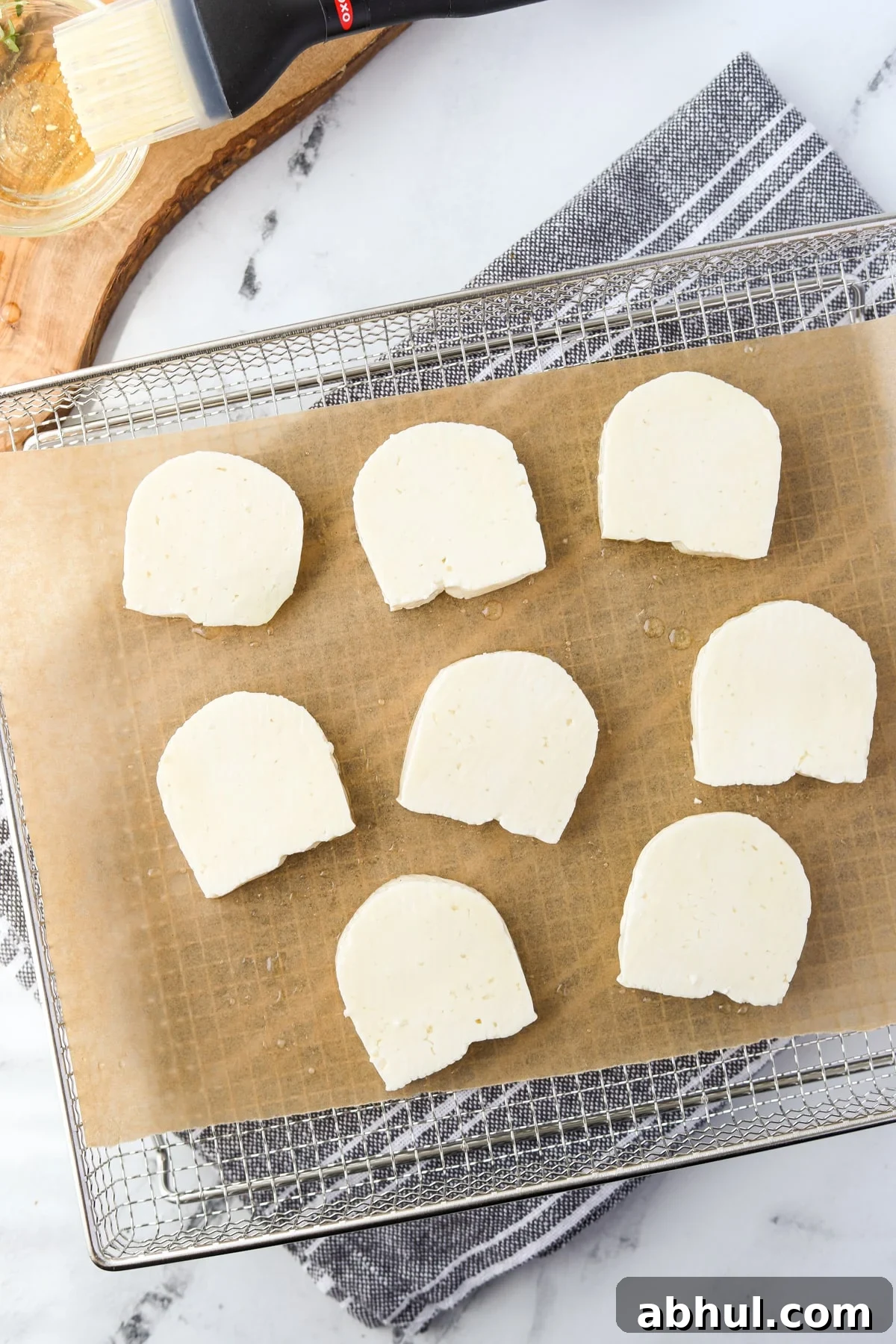 An air fryer tray with halloumi cheese slices.