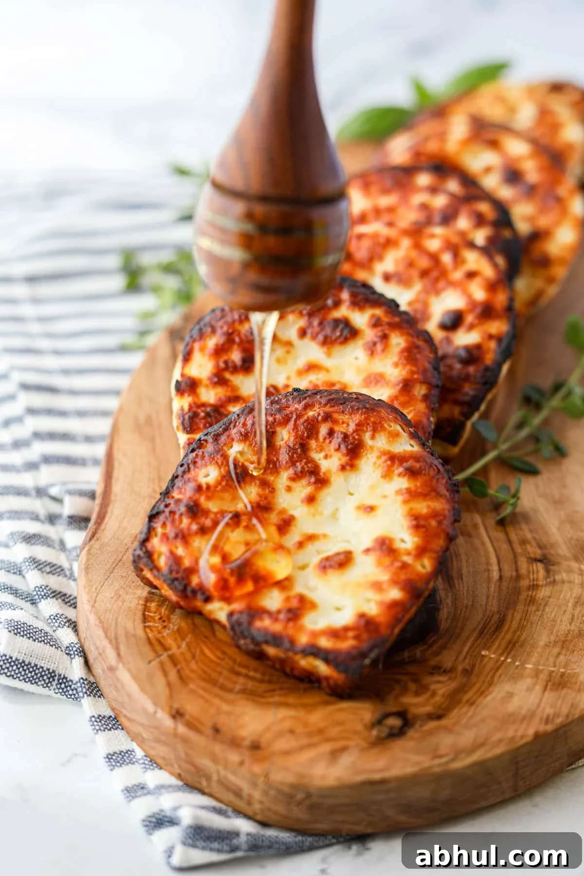Drizzling honey on fried cheese.