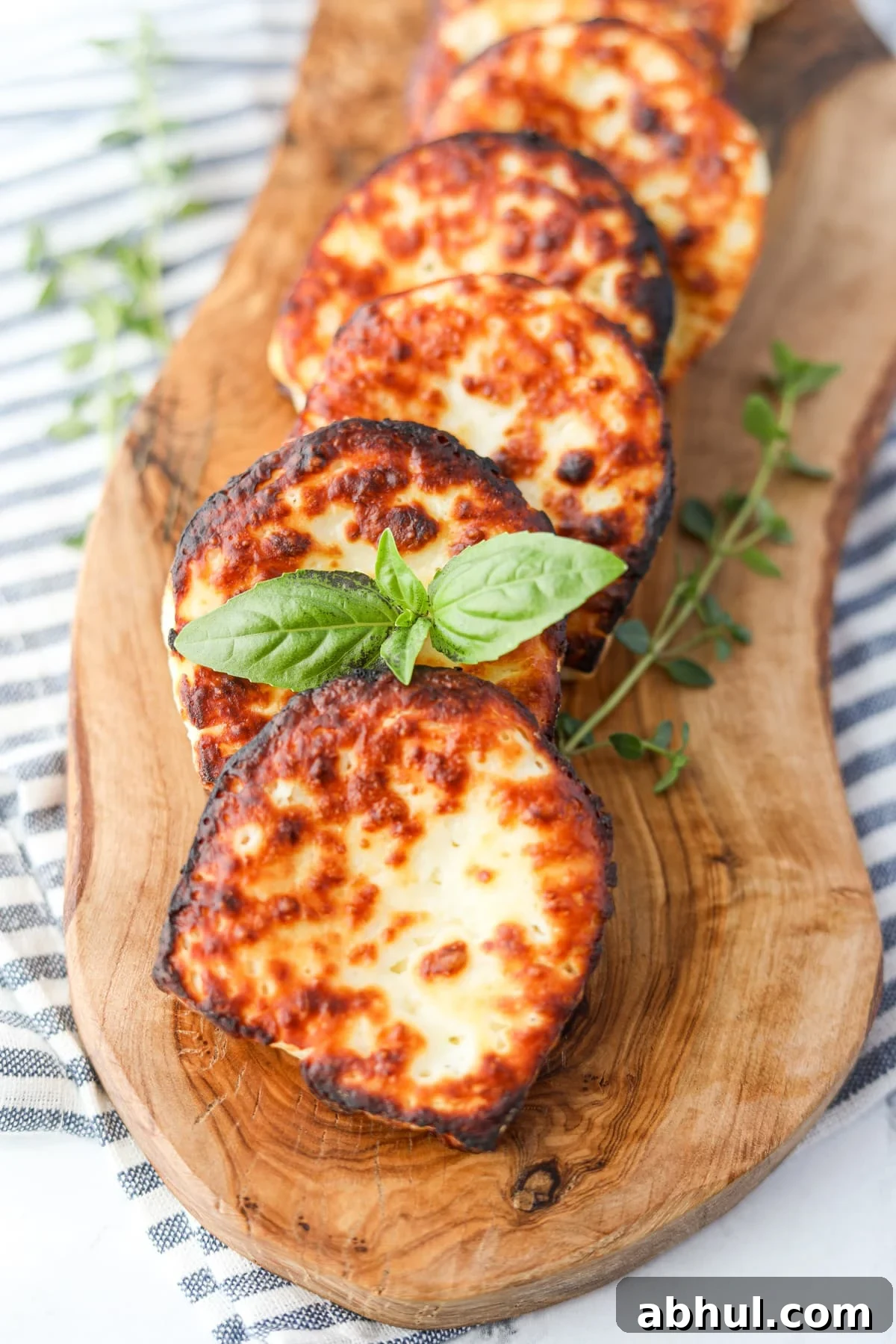 Garnishing a slice of fried halloumi cheese with fresh basil.