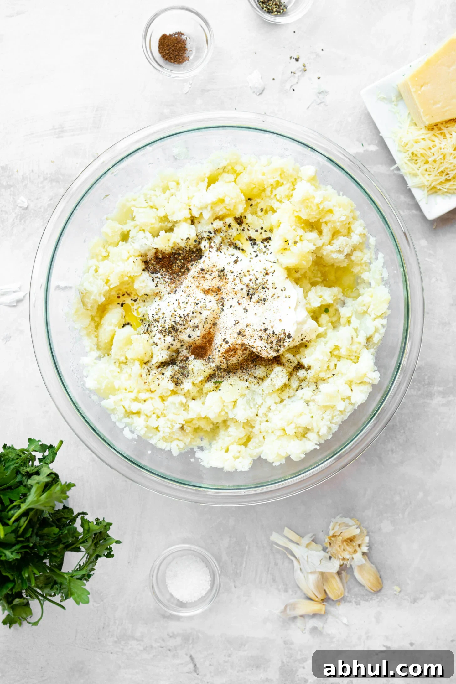 A bowl of mashed potatoes with spices and sour cream.