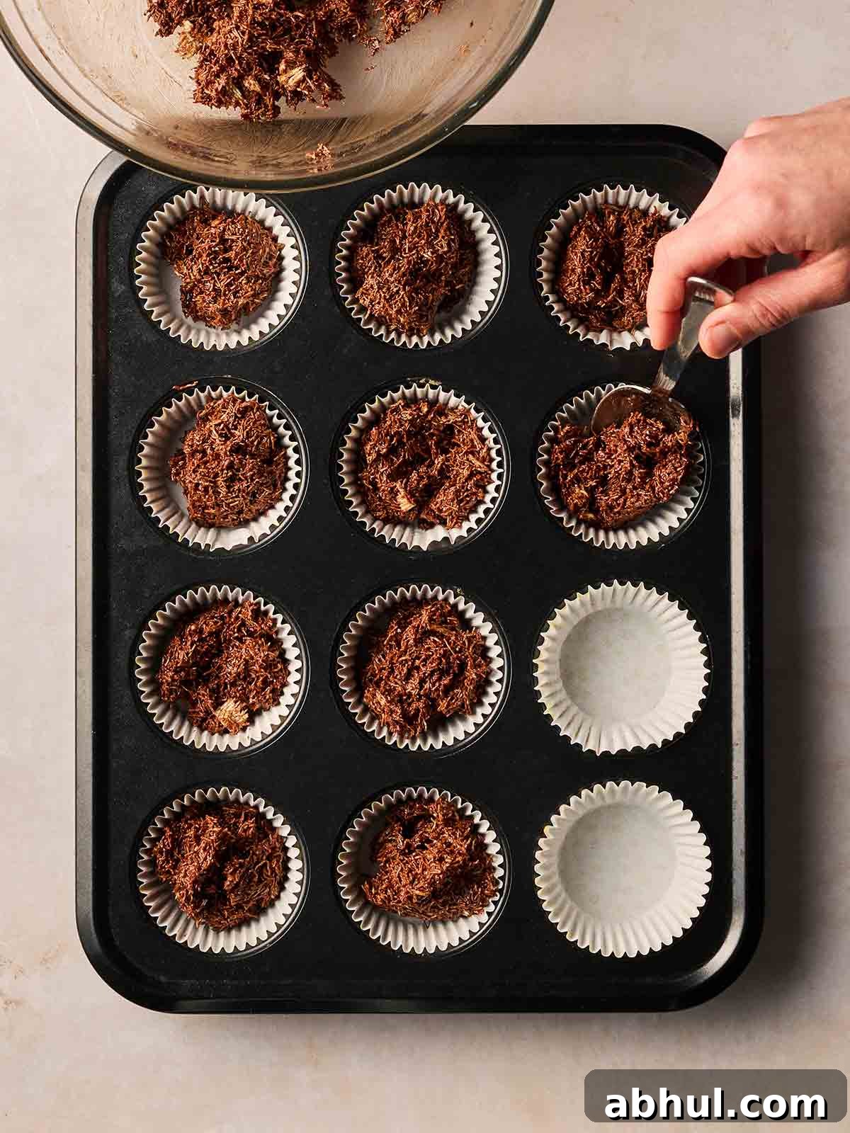 A baking tray with Easter Nests inside the holes, ready to set.