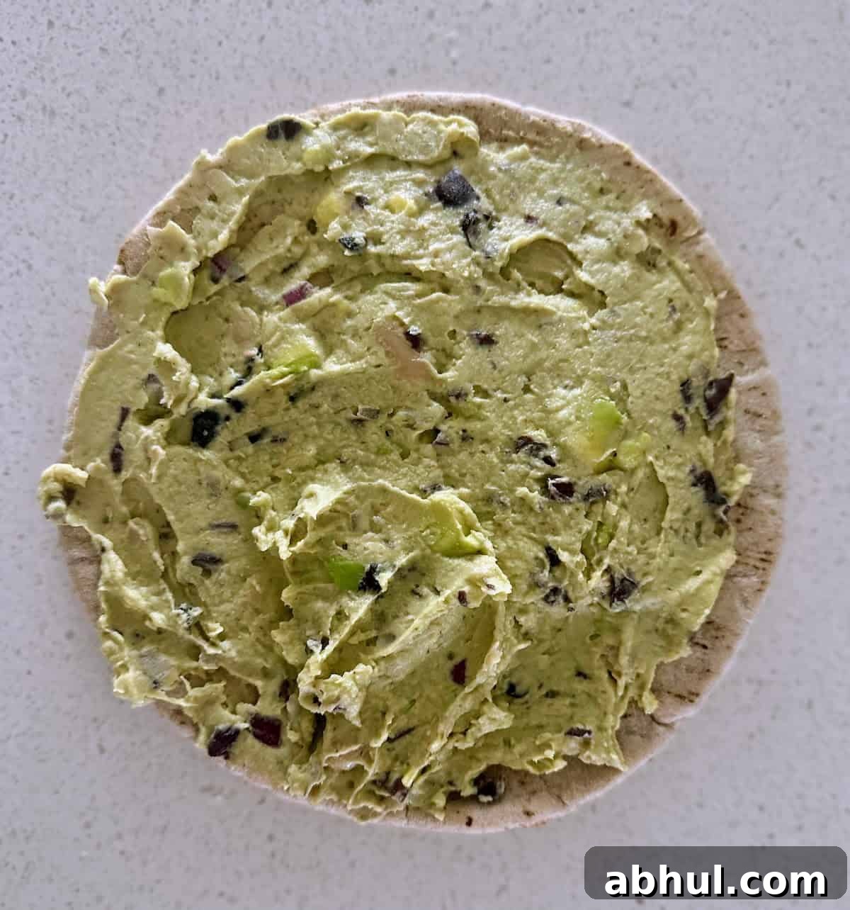 White beans and avocado dip spread on top of pita bread. 