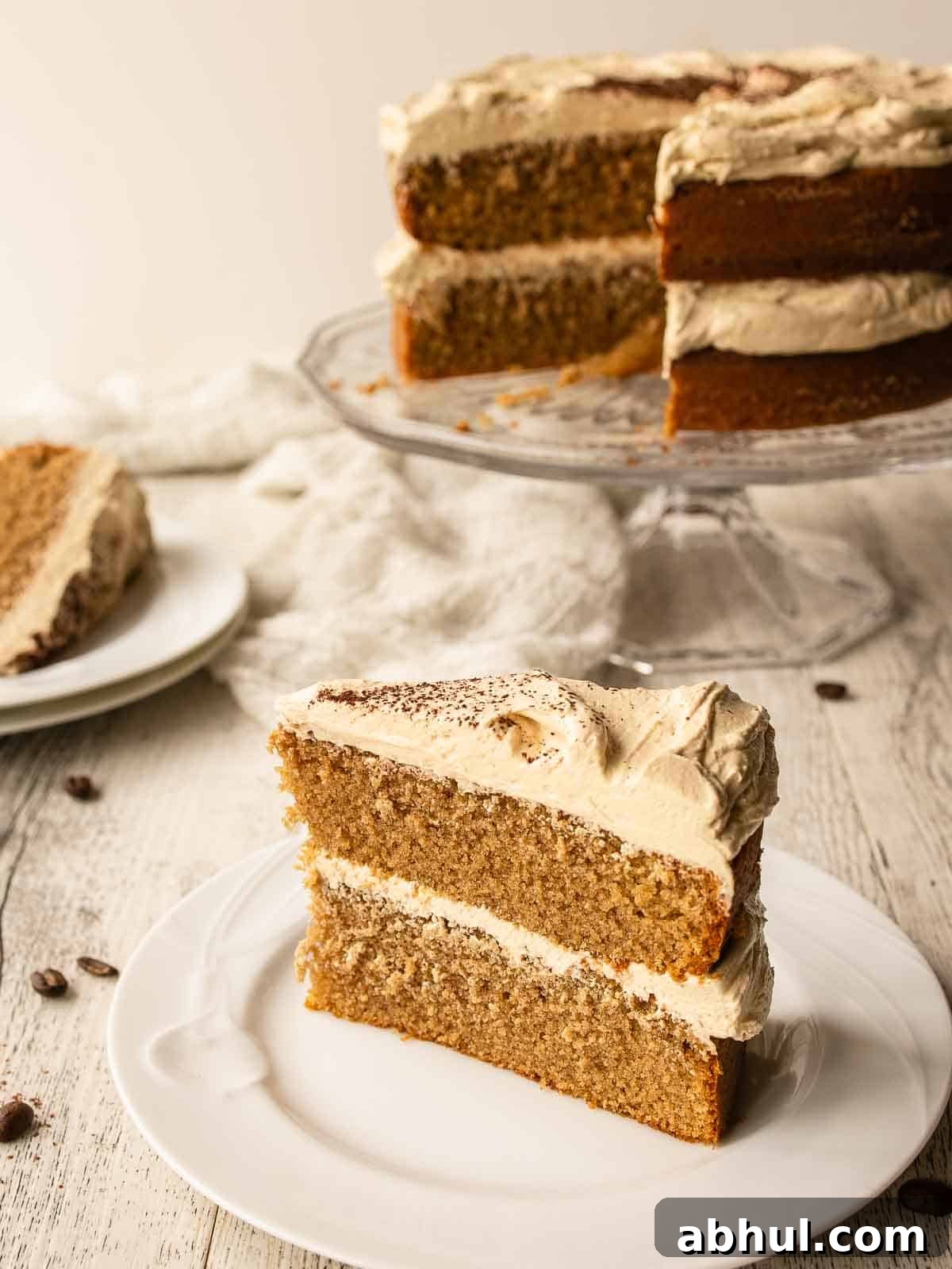 Cappuccino Cake with a slice on a plate and remaining cake in background.