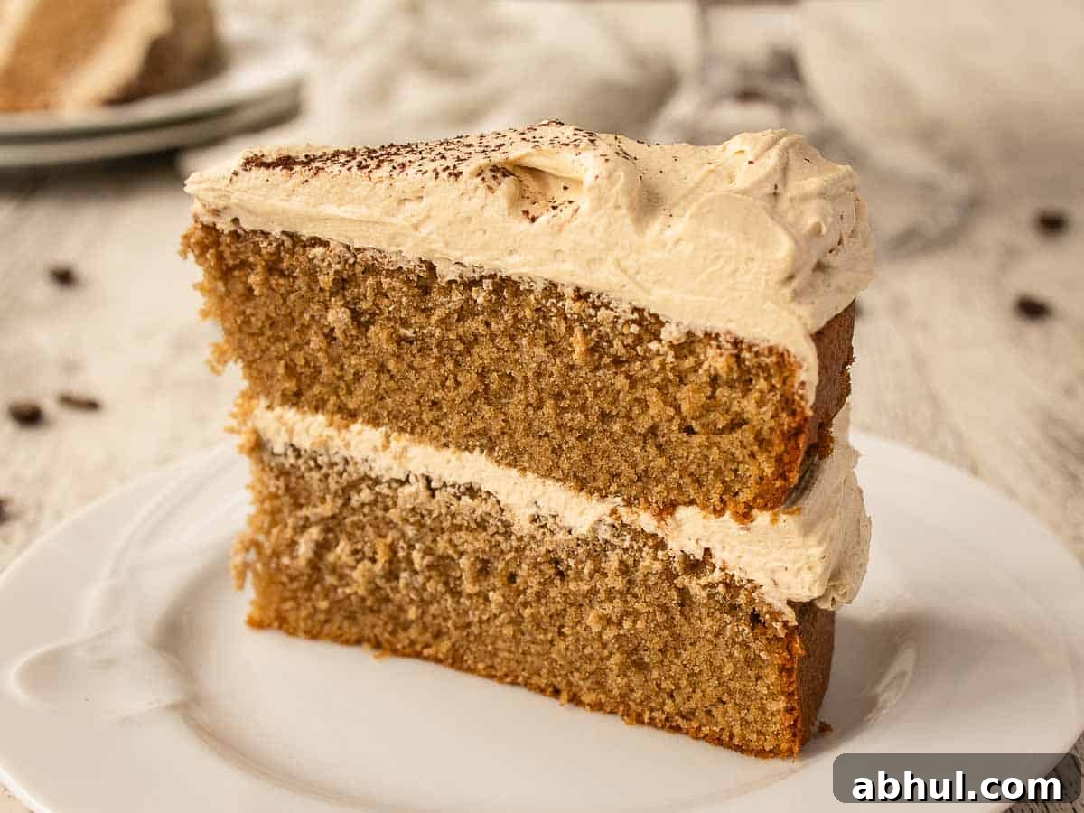 Close up of a wedge of two layer cake filled and topped with buttercream.