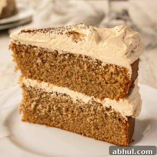 Close up of a wedge of two layer cake filled and topped with buttercream.