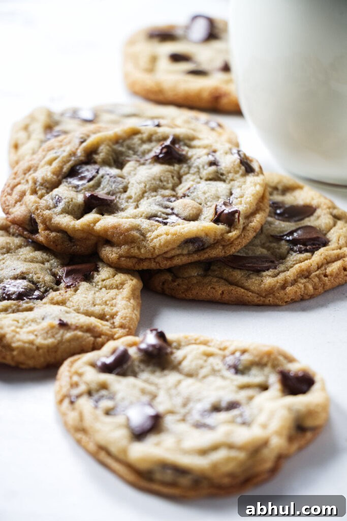 A pile of cookies next to a glass of milk.