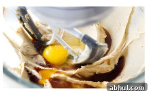 Adding eggs to cookie dough.