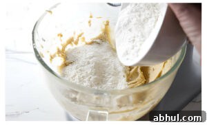 Adding flour to cookie dough.