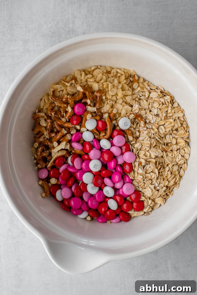 The dry ingredients for M&M pretzel granola bars, in a white mixing bowl ready to be stirred.