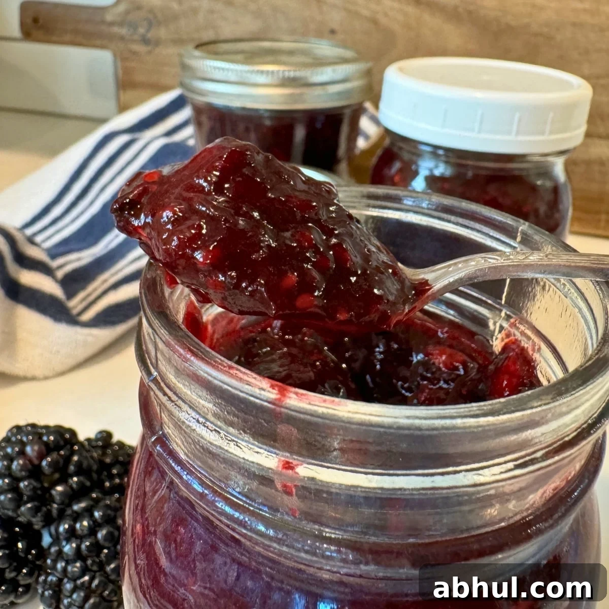 Low-Sugar No-Cook Blackberry Freezer Jam (No Pectin) 2 up close blackberry freezer jam in jar with spoonful
