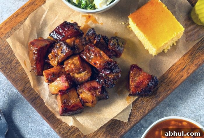 smoked chuck roast poor man's burnt ends served on chopping board with bbq sides