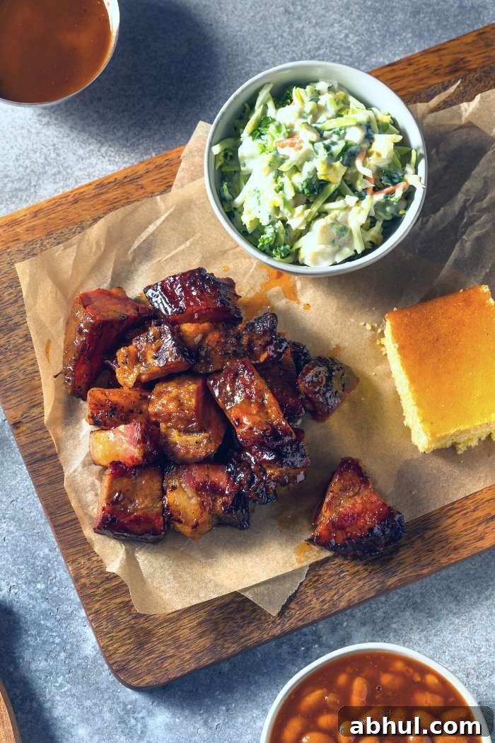 smoked chuck roast poor man's burnt ends served on chopping board with bbq sides