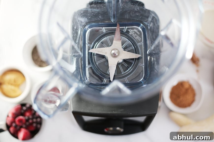 Ingredients arranged around the blender to make the superfood berry smoothie bowl