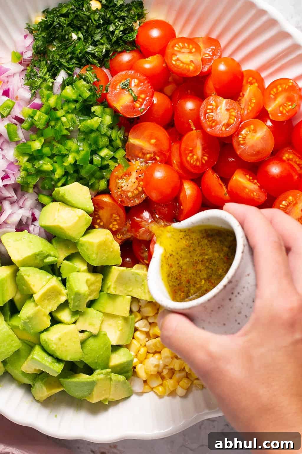 avocado corn salad pouring dressing