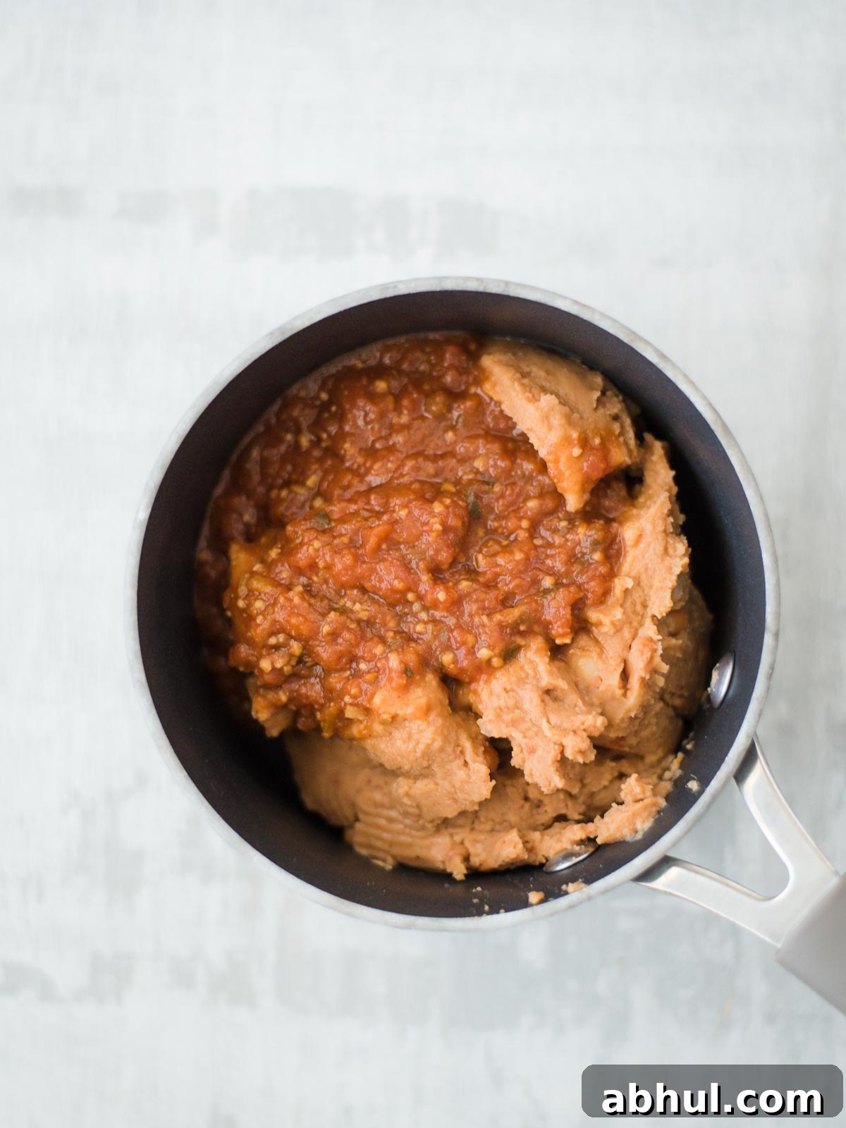 refried beans with salsa in sauce pan
