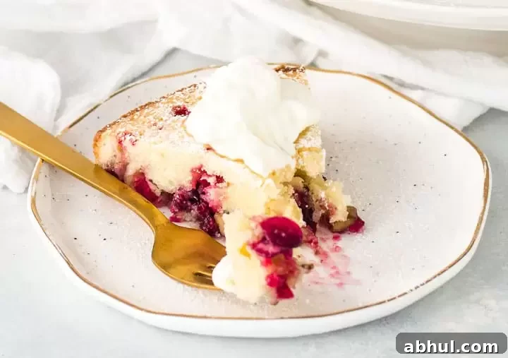 slice of Nantucket cranberry pie on a plate with a fork taking a bite out of it