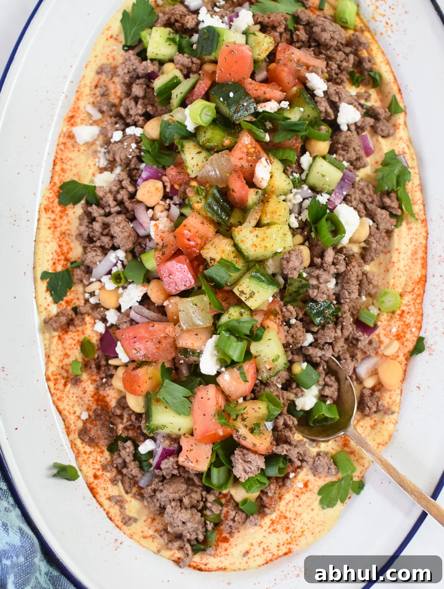 Ground Beef Layered Hummus with garnishes. 