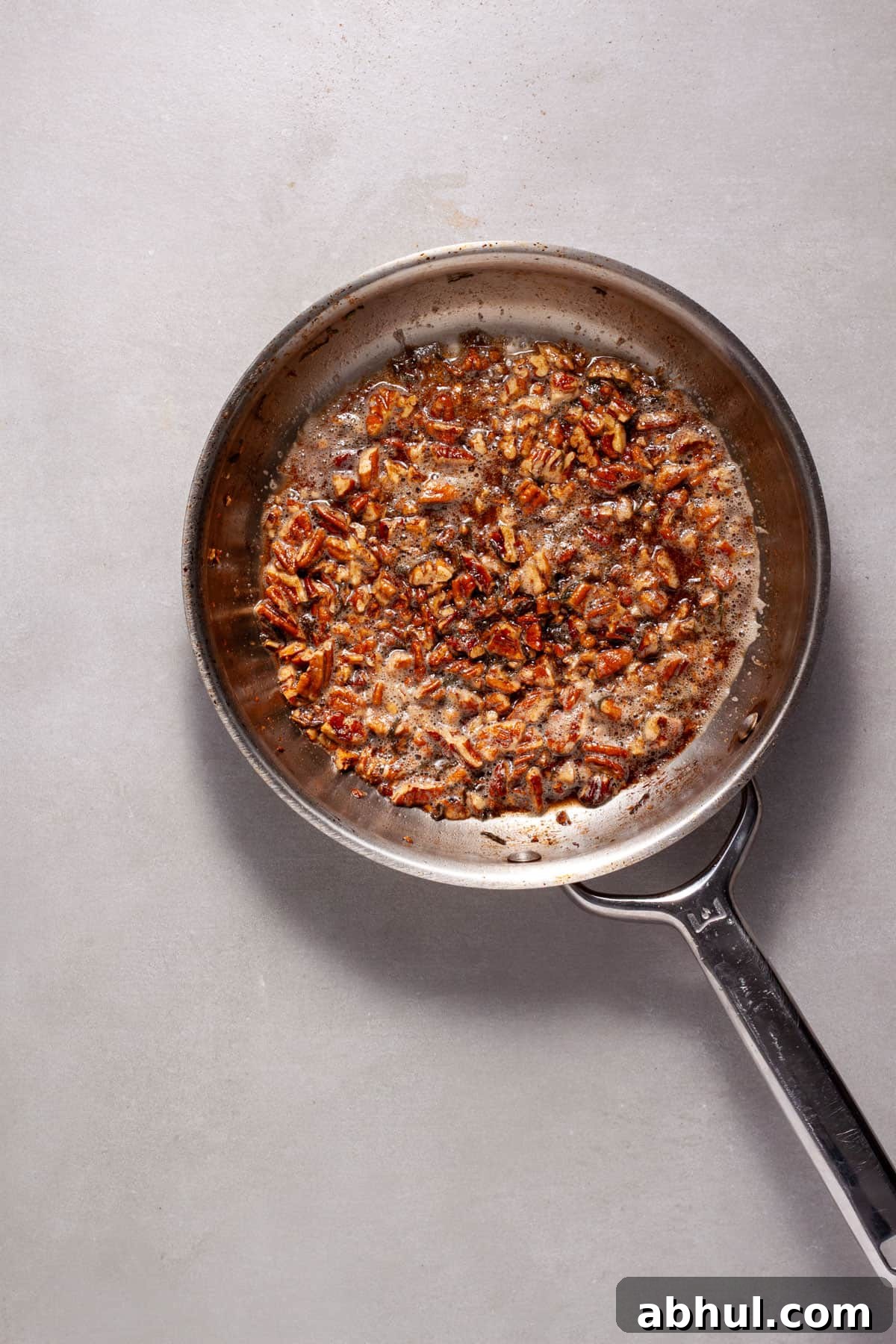 Maple-Pecan Roasted Honeynut Squash Recipe 7 Toasted pecans with maple syrup and sage in a small skillet.