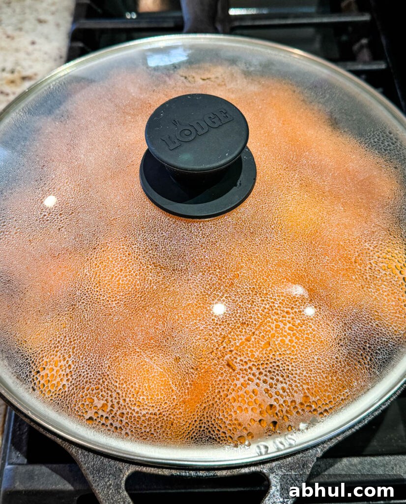 Crispy Fried Sweet Potatoes with Honey and Cinnamon 8 fried sweet potatoes in a cast iron skillet covered with a lid