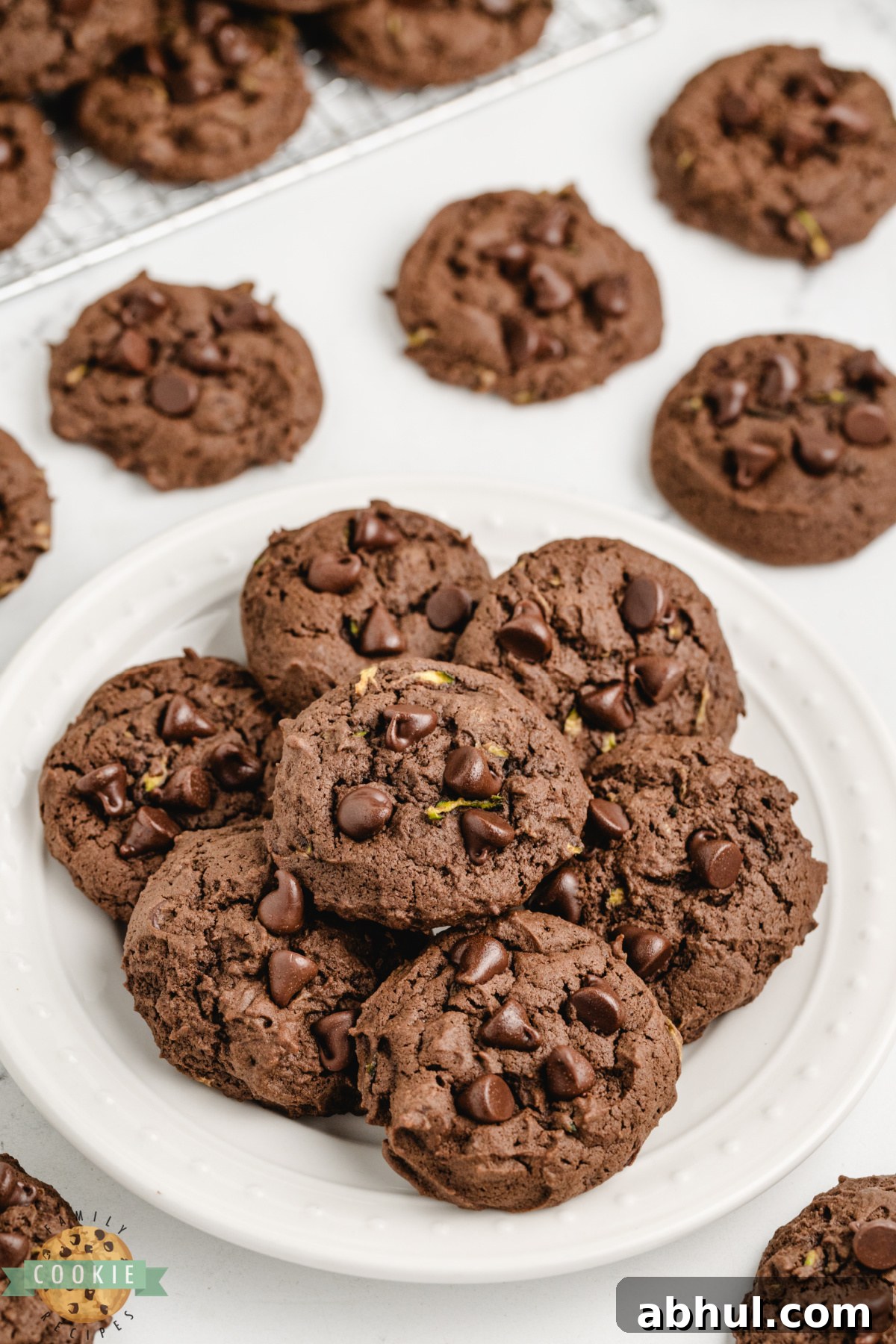 Pile of chocolate zucchini cookies on a white plate.
