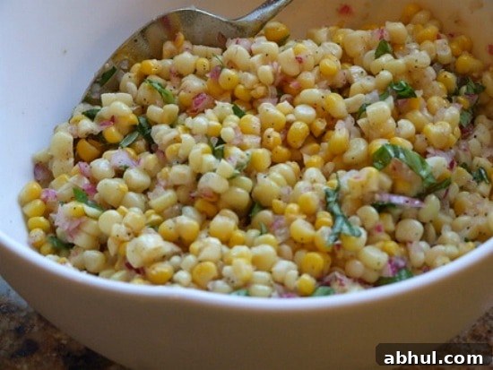 Fresh Corn Salad Fresh Corn Salad in a white serving bowl with a serving spoon