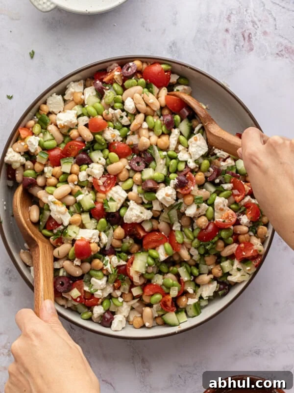 High protein bean salad being mixed in a large bowl.
