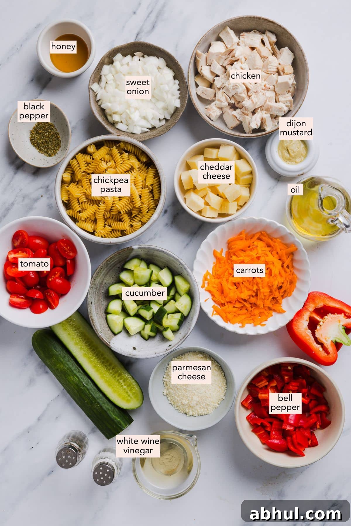 High protein pasta salad ingredients on a countertop with labels.