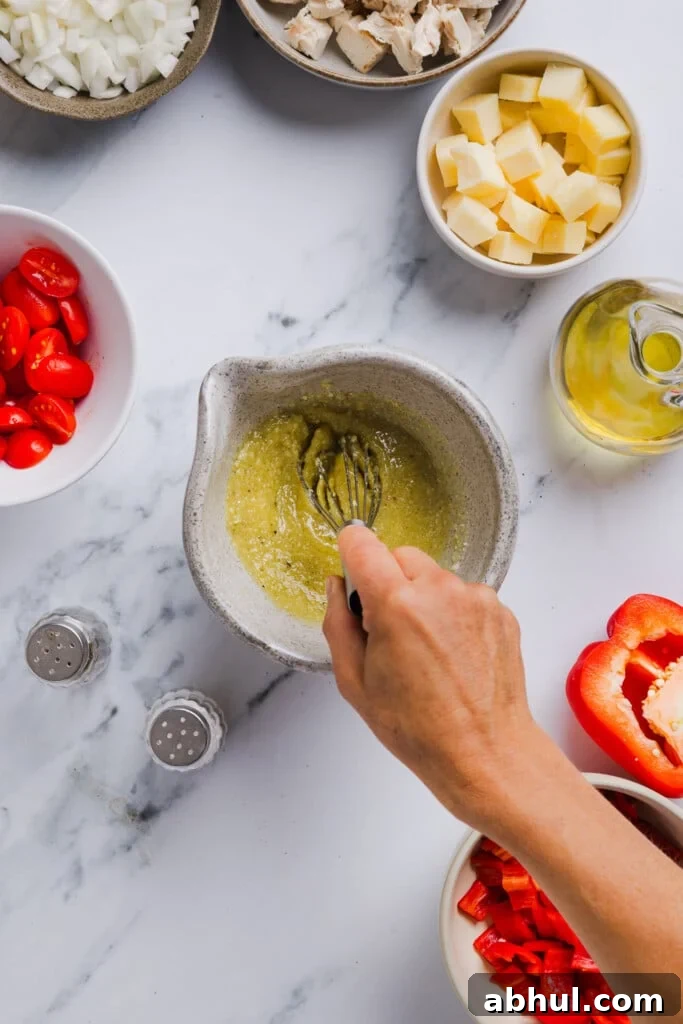 Dressing for high protein pasta salad being mixed up in a small bowl.