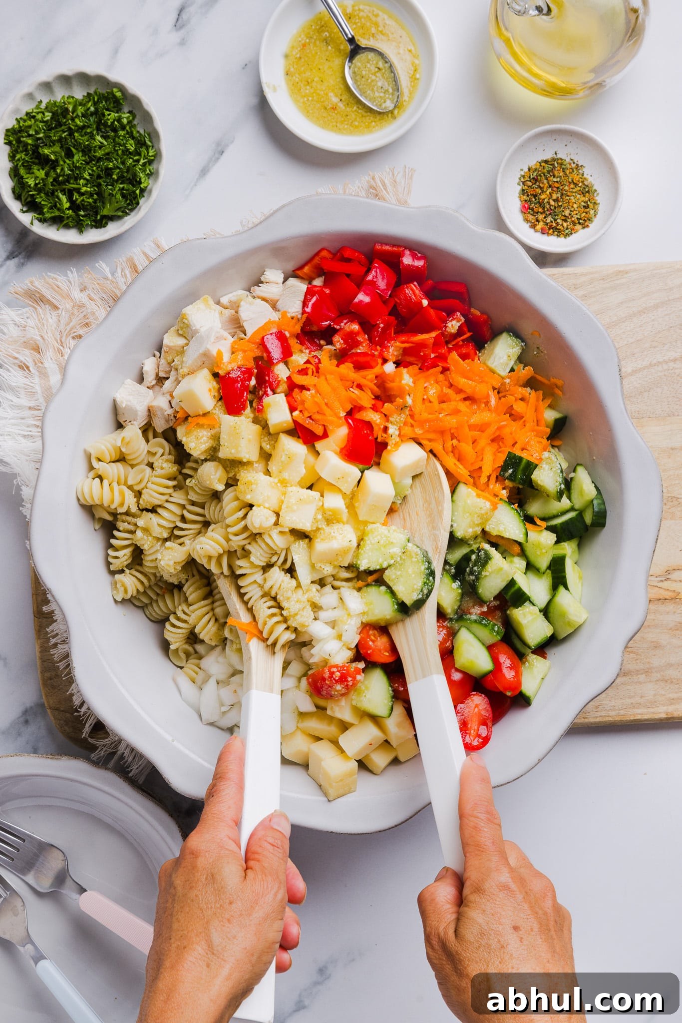 High protein pasta salad being mixed up in a large bowl.
