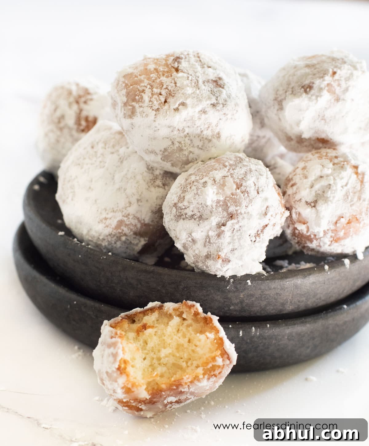 A close up of a donut hole with a bite taken out.