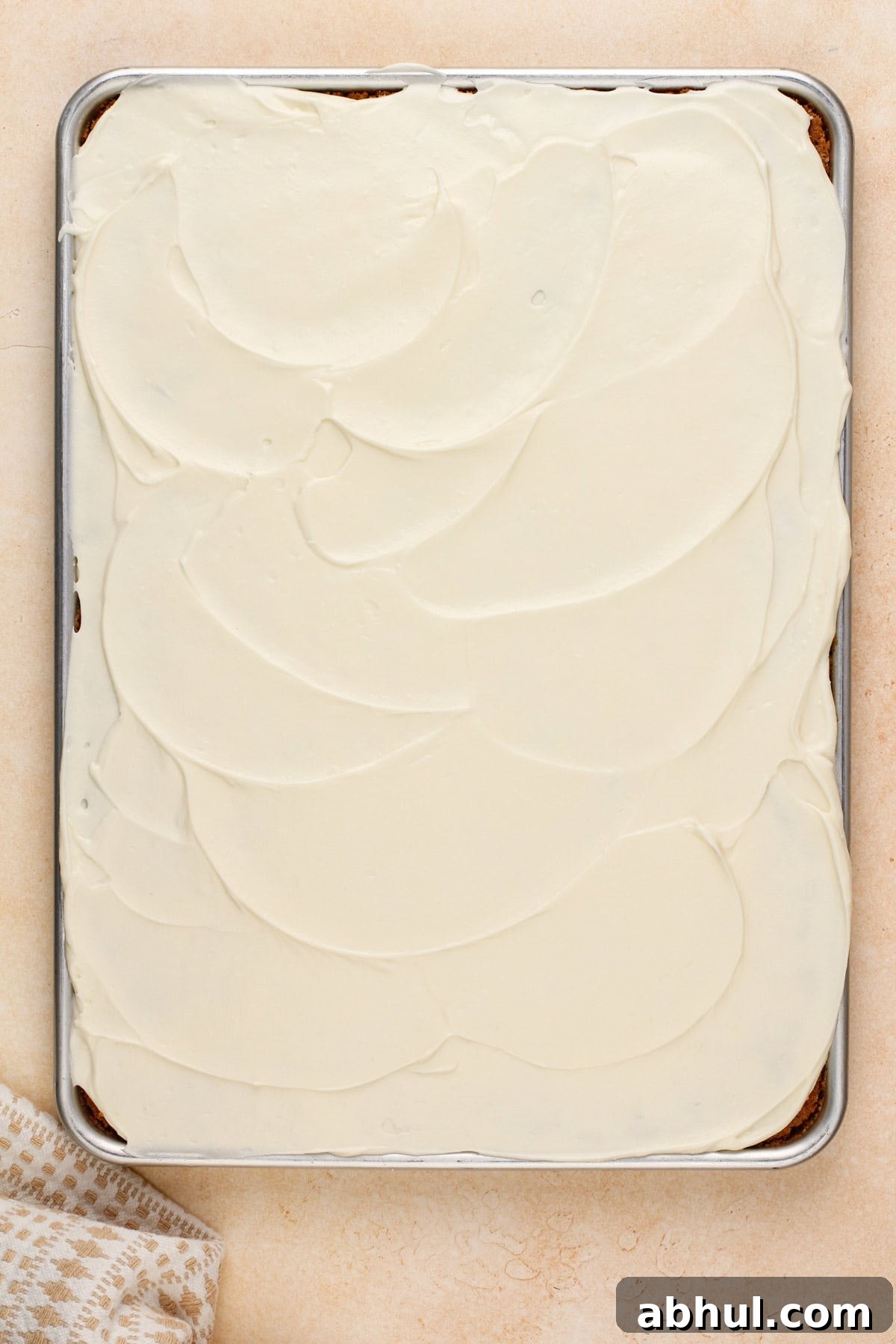 Frosted carrot cake bars in a half sheet pan.
