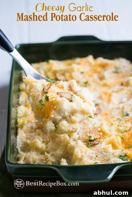 Cheesy Garlic Mashed Potato Casserole Bake Recipe in casserole with spoon 