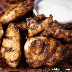 Jerk chicken wings and a cup of ranch on butcher paper.