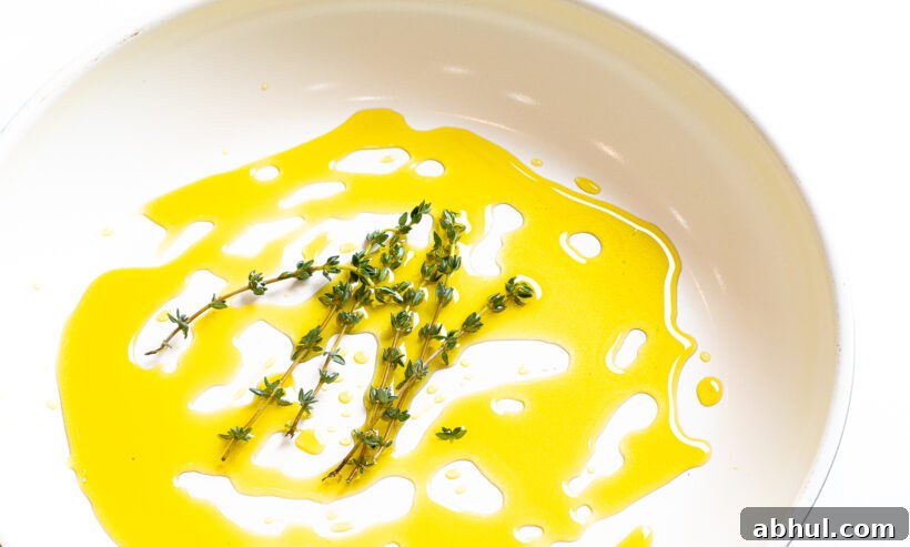 Olive oil and thyme sprigs in a skillet. 