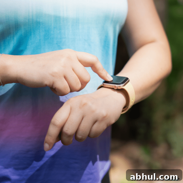 Person tapping a smartwatch screen to track health data and manage digital health monitoring on the go.