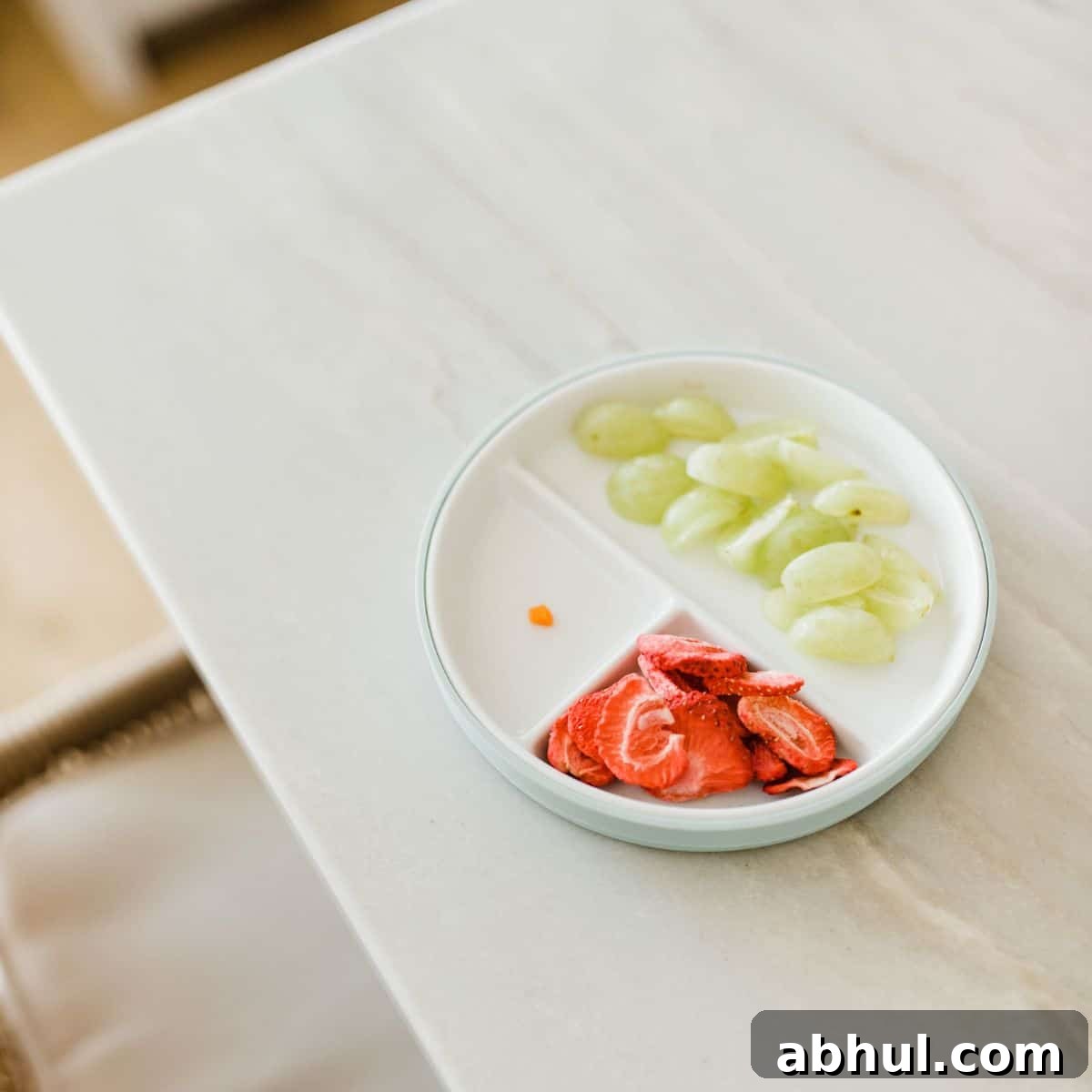 Plate with grapes, strawberries and a small piece of carrot