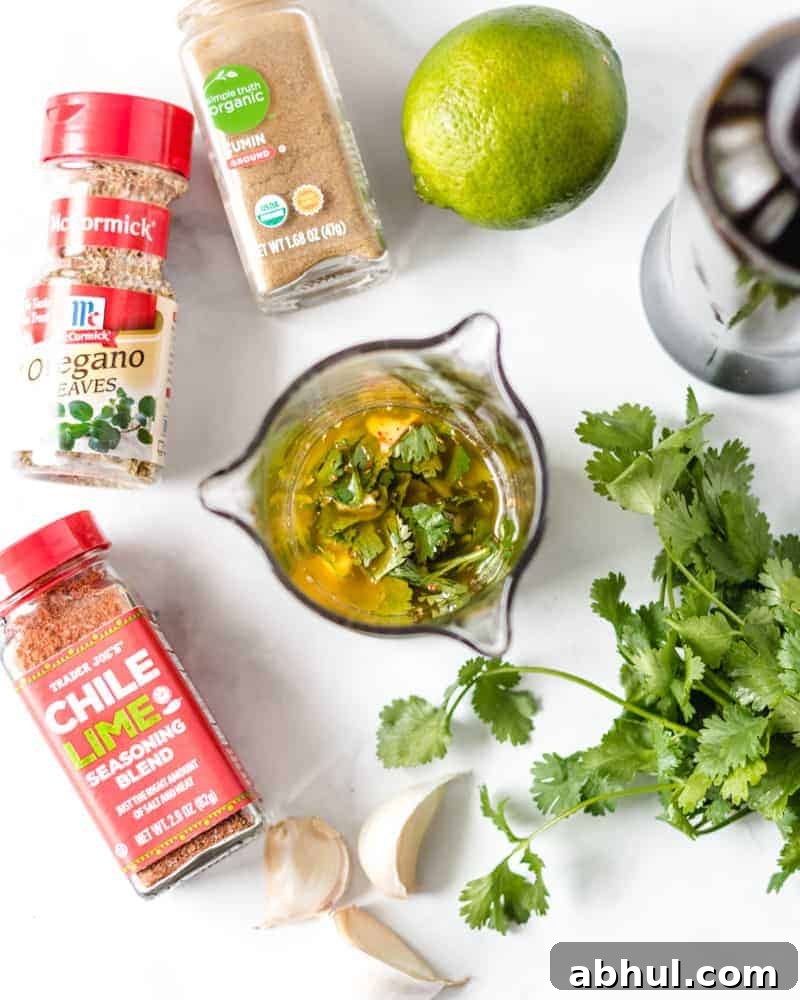 Zesty Mexican Citrus Marinade for Juicy Chicken 3 Chicken fajita marinade in a glass cup with ingredients surrounding it.